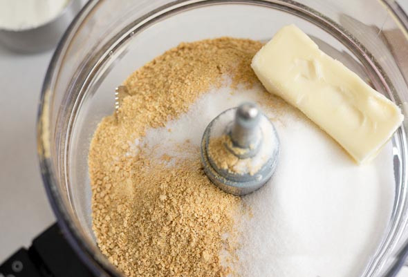 1. Этап. Классический чизкейк: 1. В блендере измельчите крекеры в крошку, добавьте в чашу сливочное масло и пару ложек сахара. Перемешайте и соберите тесто в шар.