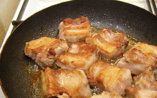 1. Этап. Свиные ребра, тушенные с картошкой: Обжарьте ребрышки на сковороде на сильном огне до образования аппетитной корочки с двух сторон. Переложите их в сотейник с толстым дном.