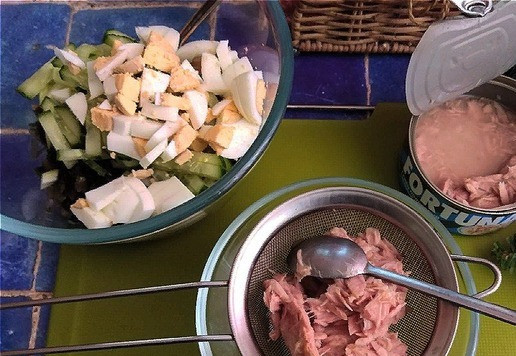 1. Этап. Салат с тунцом и морской капустой: Отправляем все овощи к капусте. Рубим яйца не совсем уж мелко и тоже отправляем в салатник. В салате я буду использовать тунец рубленный в с/с ТМ FORTUNA. Открыла баночку. Выложила кусочки на ситечко и ложкой прижала. Дала стечь полностью жидкости. Не такие уж мелкие в баночке кусочки и я их ещё немного покрошила.