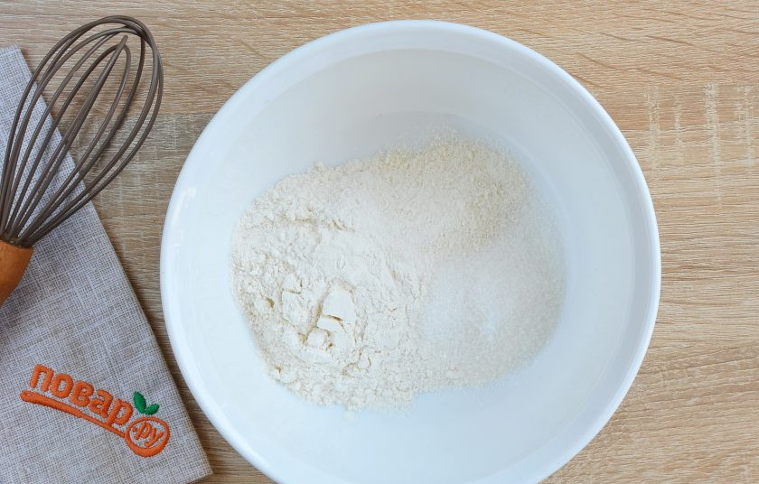 1. Этап. Яблочные пончики: В миске смешайте сначала сухие ингредиенты: муку, сахар, разрыхлитель.