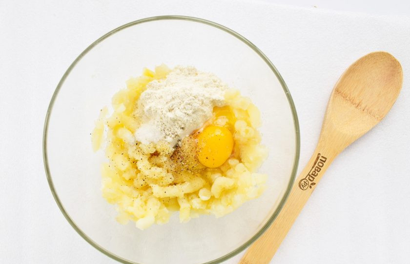 1. Этап. Картопляники с постной начинкой: Подготовьте необходимые продукты. Картофель заранее отварите в мундирах до мягкости, немного остудите, очистите и измельчите в пюре. Добавьте соль, черный молотый перец, яйцо, муку, перемешайте до однородности. Тесто получится очень мягким.