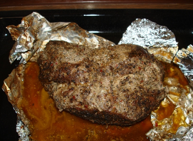 1. Этап. Свинина с чесноком в духовке: 6. Духовку хорошо разогреть. Аккуратно выложить на противень мясо и запекать около 2 часов. За 10-15 минут до готовности можно слегка надрезать фольгу, чтобы мясо лучше подрумянилось. Подавать свинину с чесноком в духовке в домашних условиях можно как в горячем, так и в холодном виде.