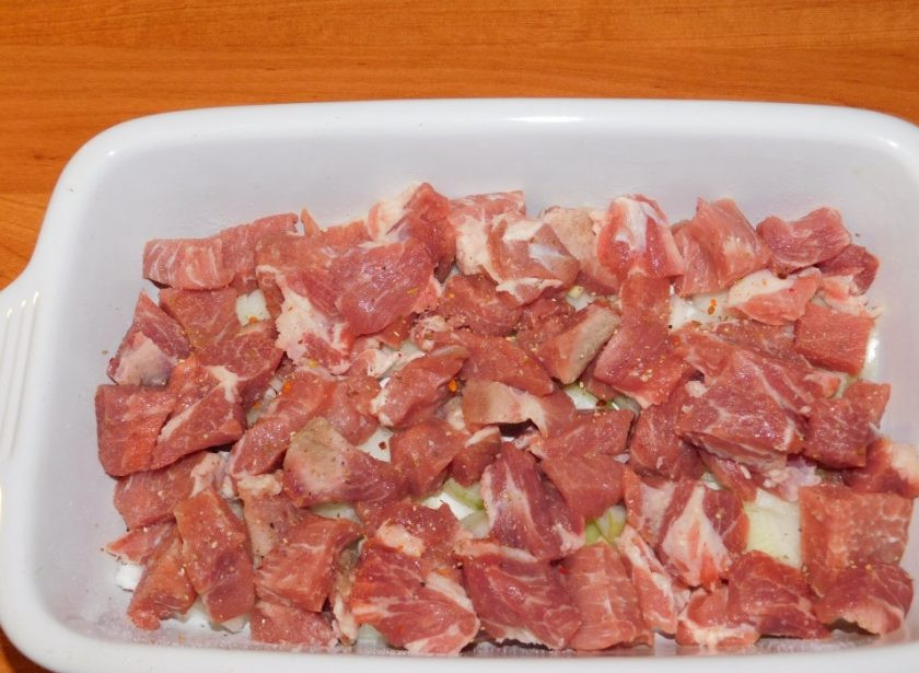 1. Этап. Сытная мясная запеканка с картофелем: Затем выложите нарезанное мясо. Добавьте по вкусу соль и специи.