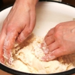 1. Этап. Постные пирожки с капустой: Небольшими порциями добавляем жидкую смесь к сухой, руками замешиваем тесто.