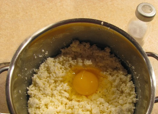 1. Этап. Рецепт домашнего сыра из молока и творога: Затем остывшую творожную массу перекладываем в кастрюлю, добавляем туда соль, соду и яйцо, хорошо перемешиваем до однородного состояния.