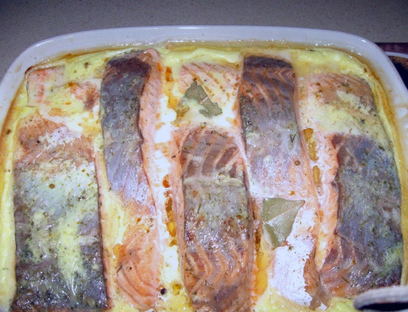 1. Этап. Красная рыба в сливочном соусе в духовке: Смазываем противень растительным маслом. Его можно налить побольше, чем для выпечки. Выкладываем кусочки рыбы плотно друг к другу, заливаем все сливочным соусом. Кидаем перчик горошком и лавровый лист для запаха. Ставим в духовку при температуре 150 градусов на 40 минут.