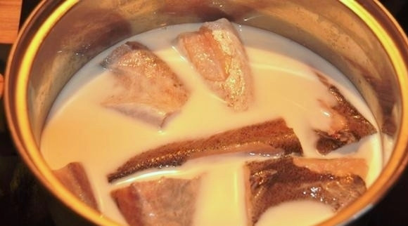 1. Этап. Салат из минтая: Попутно варим нашу рыбу в молоке. Но прежде чем начать варить, сначала рыбу разморозим при комнатной температуре, хорошо ее промоем под проточной водой и нарежем кусками. Затем уже варим ее в молоке около 15-20 минут. Затем не вынимая (!) из молока, остужаем ее. После того как она полностью остынет, достанем минтая из молока и отделим филе от костей, кожи и нарежем на мелкие кусочки.