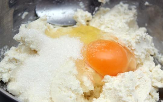 1. Этап. Ватрушки: 3. Займемся начинкой: с сахаром и яйцами смешиваем творог, сюда же добавляем изюм вместе с ромом. Все хорошенько перемешиваем.