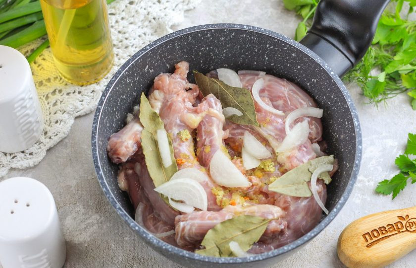 1. Этап. Вареные куриные шеи: Нарежьте полукольцами очищенный и промытый репчатый лук. Всыпьте нарезку вместе с лавровыми листьями и приправой в емкость. По желанию вы можете добавить и другие приправы и специи.