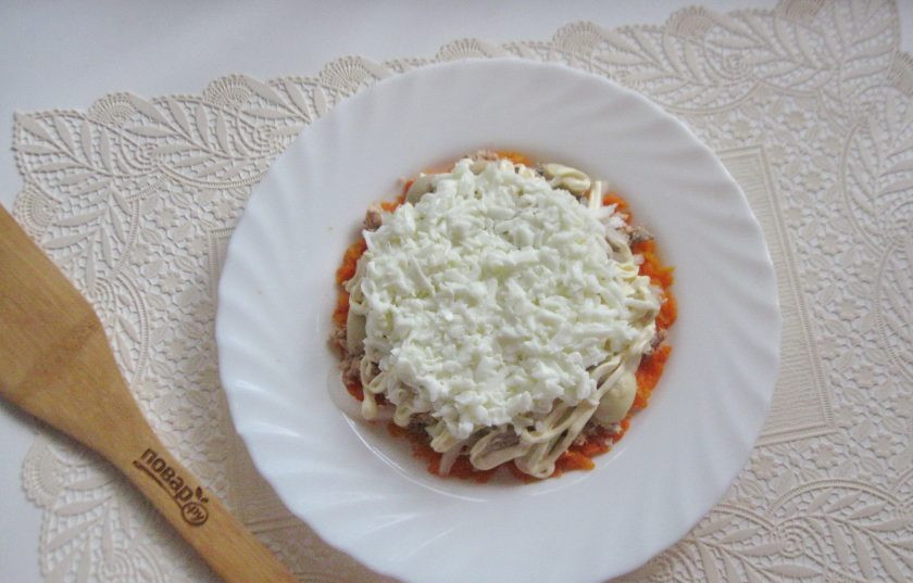 1. Этап. Салат с консервированной горбушей и грибами: Яйца сварите вкрутую, охладите, очистите. Отделите белки от желтков. Натрите белки на терке и выложите на салат.