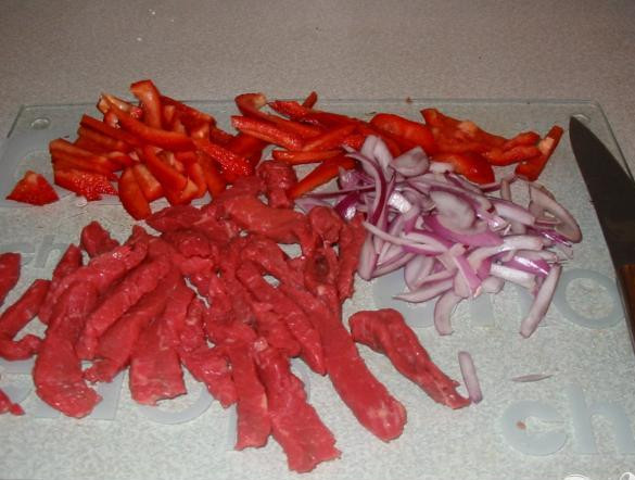 1. Этап. Мясная зажарка: 1. Нарезать говядину мелкими полосками. Удалить семена из красного перца и нарезать полосками. Тонко нарезать лук. Мелко нарезать чеснок. Бульонный кубик раскрошить в блюдце.