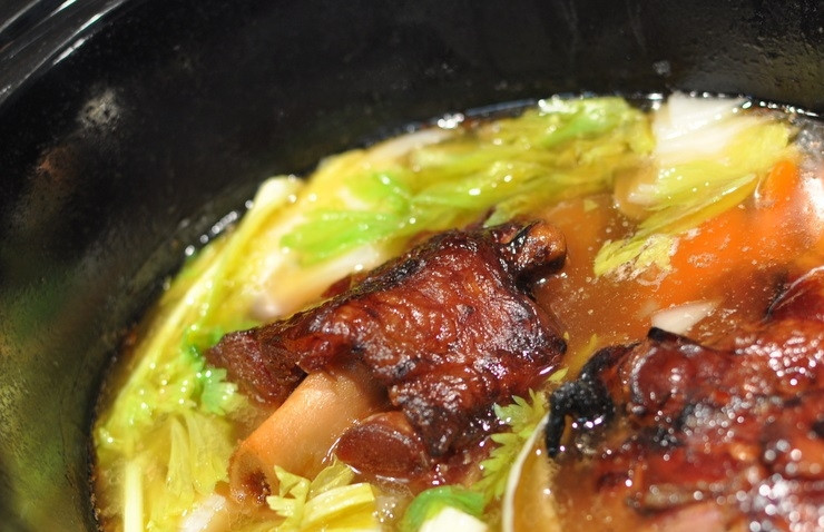 1. Этап. Простой гороховый суп с копченостями: 1. Сперва сделайте бульон: в кастрюлю выложите копченую рульку на кости, залейте её водой, добавьте 1 луковицу, 2 моркови и 1 стебель сельдерея, нарезанные крупно. Варите 2-3 часа на слабом огне. Достаньте рульку, процедите бульон и избавьтесь от овощей, очистите мясо.