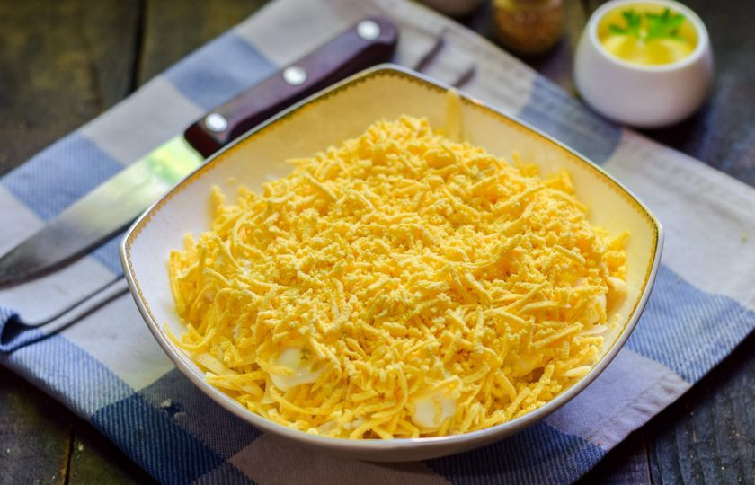 1. Этап. Салат Царский с ананасами: Завершающий слой салата — куриные желтки, натертые на мелкой терке.