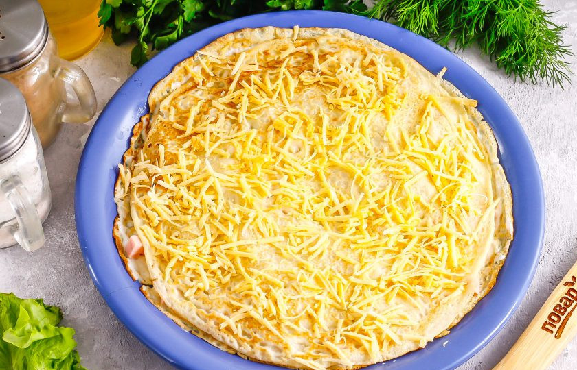 1. Этап. Блинный торт с ветчиной и сыром: Накройте вторым блином и смажьте его сметаной, выложите на блин сырную нарезку, но не всю, оставляя и для других слоев.