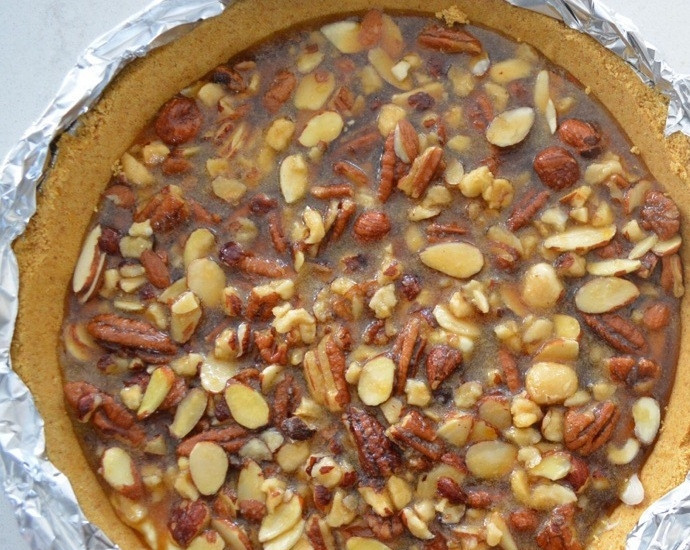 1. Этап. Чизкейк Грильяжный: 6. Аккуратно распределите карамель с орешками на сливочный крем. Запекайте чизкейк в духовке в течение часа. После приготовления обязательно остудите десерт при комнатной температуре.