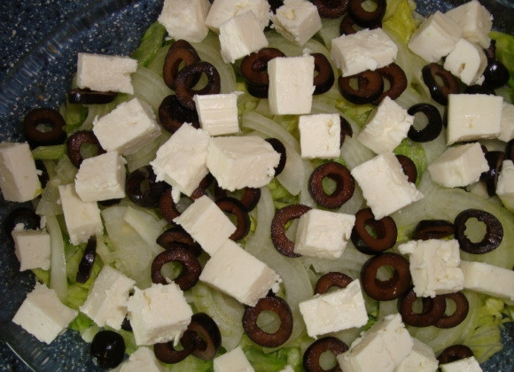 1. Этап. Cалат с фетой и оливками: Салат посолите, полейте оливковым маслом. А сверху выложите сыр Фета, нарезанный кубиками и посыпьте рубленной свежей зеленью. Салат с фетой и оливками готов.