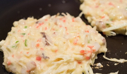 1. Этап. Окономияки: 7. Выложите лепешки на сковороду, жарьте под крышкой 2-3 минуты на минимальном огне.