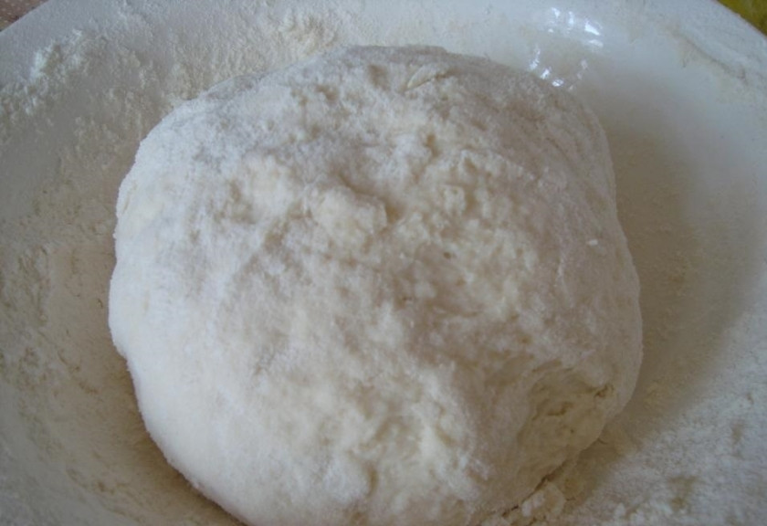 1. Этап. Колбаса в тесте: 1. В миску вбиваем яйцо, добавляем щепотку соли и перемешиваем. Вливаем кефир и водку, которую можно заменить минеральной водой. Всыпаем порционно заранее просеянную муку и делаем замес. Тесто получается эластичным и мягким, не забиваем его мукой.