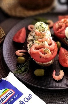 1. Этап. Бутерброды с творожным сыром и креветками: Подаём и перекусываем или завтракаем. Вот такие красивые и полезные бутерброды у нас получились. Всё в них есть: и белок; и жиры; и углеводы; и клетчатка. Легко, сытно, вкусно! По порциям - кто сколько съест. Остатки креветок, помидора помещаем на тарелку, украшаем веточками укропа и оливками. Оливки - по желанию конечно.