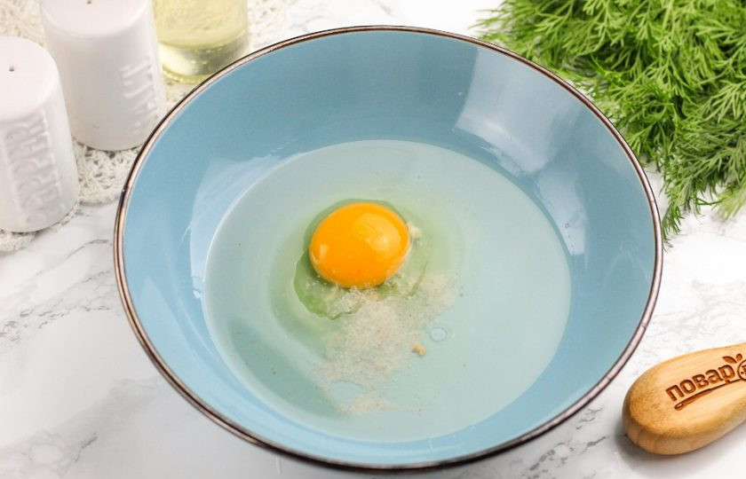 1. Этап. Пирог со свининой: Вбейте в глубокую емкость куриное яйцо, влейте растительное масло и воду. Всыпьте соль и взбейте все венчиком в течение 2-3 минут.