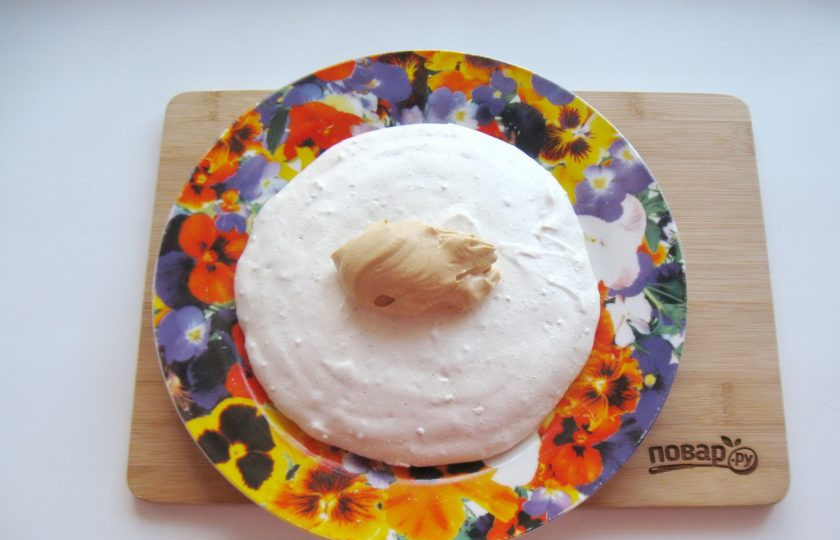 1. Этап. Меренговый торт: Сборка торта. На один корж выложите три столовые ложки крема.