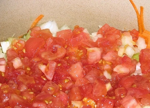 1. Этап. Салат Кубанский на зиму: Нарезаем помидоры, добавляем их к остальным овощам.