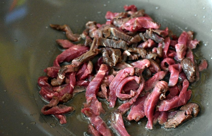 1. Этап. Маринованная говядина с овощами и зеленью: Разогрейте масло в воке и быстро обжарьте мясо до легкой корочки.