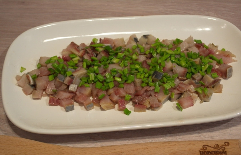 1. Этап. Салат Лисий хвост: Зеленый лук нужно нарезать мелко и выложить сверху на сельдь.