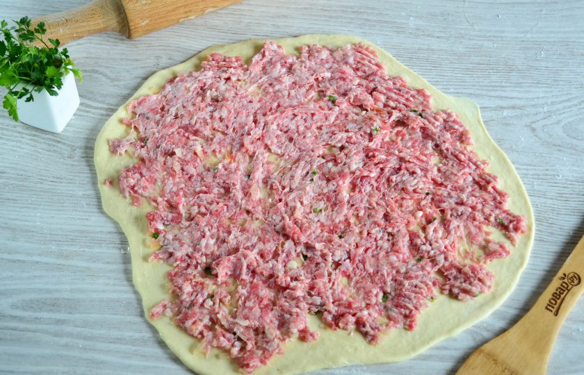 1. Этап. Ленивые пельмени на сковороде: Разделите фарш на 2 части и каждую часть распределите по раскатанному тесту.