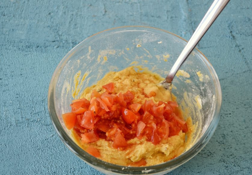 1. Этап. Нутовые лепешки: Помидоры нарежьте на мелкие кубики. Добавьте их в тесто и хорошенько перемешайте.