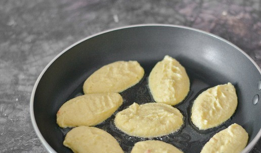 1. Этап. Оладьи из картофельного пюре с манкой: Разогрейте сковороду с маслом на среднем огне. Столовой ложкой выложите на разогретую сковороду картофельную массу в виде оладий. Жарить оладьи на первой стороне лучше под крышкой, на среднем огне, примерно 5 минут.