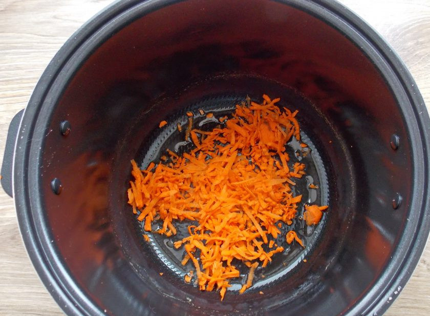 1. Этап. Говяжье сердце в мультиварке: Морковь почистите, вымойте и натрите на крупной терке. В чашу мультиварки налейте масло и выложите тертую морковь.