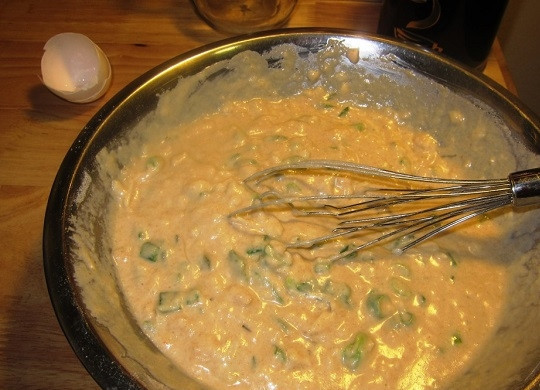 1. Этап. Закусочные оладьи с зеленым луком: 3. В сухие ингредиенты добавьте яйцо, масло, лук, тертый сыр. Тщательно перемешайте, влейте молоко.