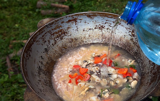 1. Этап. Паэлья в казане: 5. Влить воду и посолить по вкусу. Добавить любимые специи.