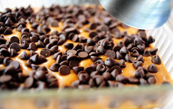 1. Этап. Шоколадные пирожные с орехами: 4. Вылить смесь поверх приготовленного пирога. Посыпать шоколадными чипсами равномерно.