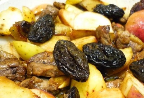 1. Этап. Утка, тушенная с черносливом и яблоком: Если в черносливе есть косточки, то удалите их предварительно. Выложите сухофрукты к грудке и яблокам в сковороду целиком. Затем посолите и поперчите блюдо по вкусу.