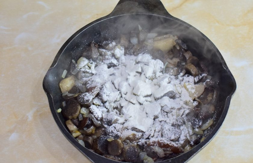 1. Этап. Печень в горшочках по-русски: Затем посыпьте грибы мукой через ситечко. Перемешайте.