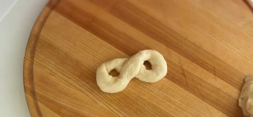 1. Этап. Булочки из детства Школьные: 4. Обомните тесто и оставьте еще на 30 минут. Затем снова обомните тесто и на рабочей поверхности разделите на 8 частей. Каждую часть скатайте в длинный жгут, соедините его концы и сложите восьмеркой.