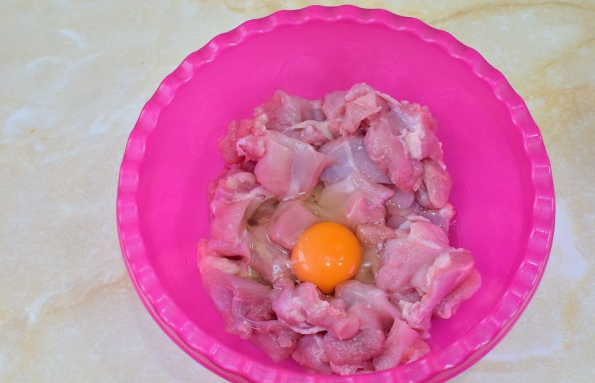 1. Этап. Оранжевый цыпленок: Куриное филе нарежьте на небольшие кусочки и смешайте его с яйцом.