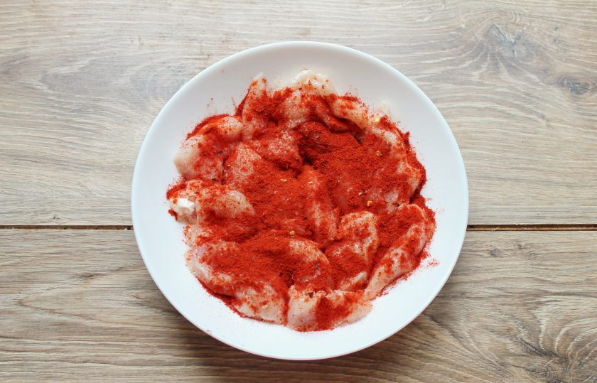 1. Этап. Куриные нагетсы в кукурузной панировке в духовке: Куриную грудку сполосните и порежьте на полоски толщиной в 1 сантиметр. Выложите куриное мясо в миску и посыпьте паприкой, солью и перцем.