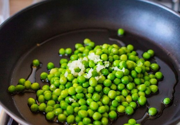 1. Этап. Куриные шарики в сливочном соусе с зеленым горошком: 5. Минут за 5 до конца запекания разогрейте оливковое масло на сковороде и выложите горошек. Добавьте пропущенный через пресс чеснок, обжаривайте несколько минут.