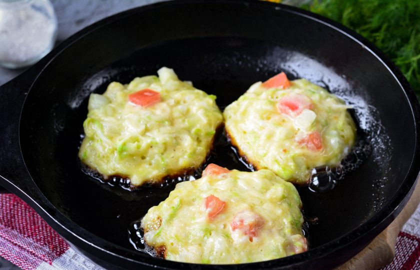 1. Этап. Оладьи из кабачков и помидоров: Разогрейте масло на сковороде и выложите ложкой оладьи.