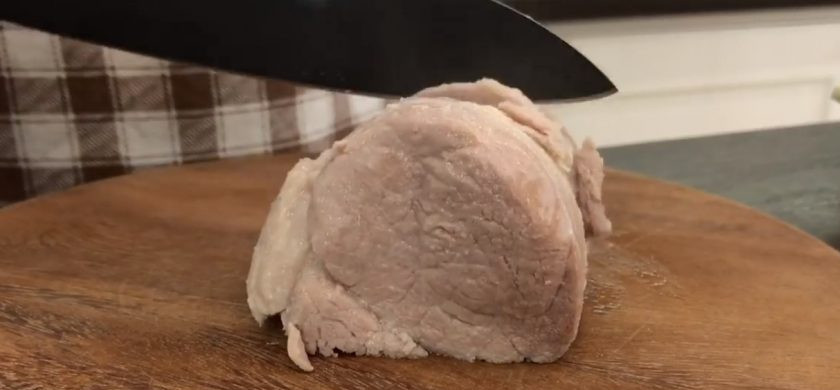 1. Этап. Вареники с мясом на заварном тесте: 4. Приготовьте начинку: в кастрюлю отправьте свиную лопатку, посолите и добавьте лавровый лист со смесью перцев. Варите на небольшом огне до готовности, после чего слегка остудите мясо и пропустите его через мясорубку (воду из кастрюли не выливайте).