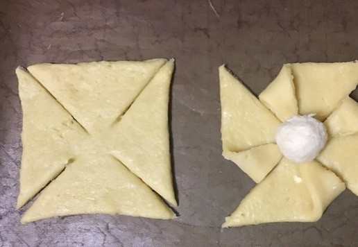 1. Этап. Печенье Вертушки: Сложите каждый второй кончик к центру и слегка припечатайте. В центр каждого квадрата выложите начинку. У меня начинка стояла в холодильнике и затвердела, и я скатала шарики, которые сохранили свою форму и после выпечки, оставаясь мягкими и нежными.