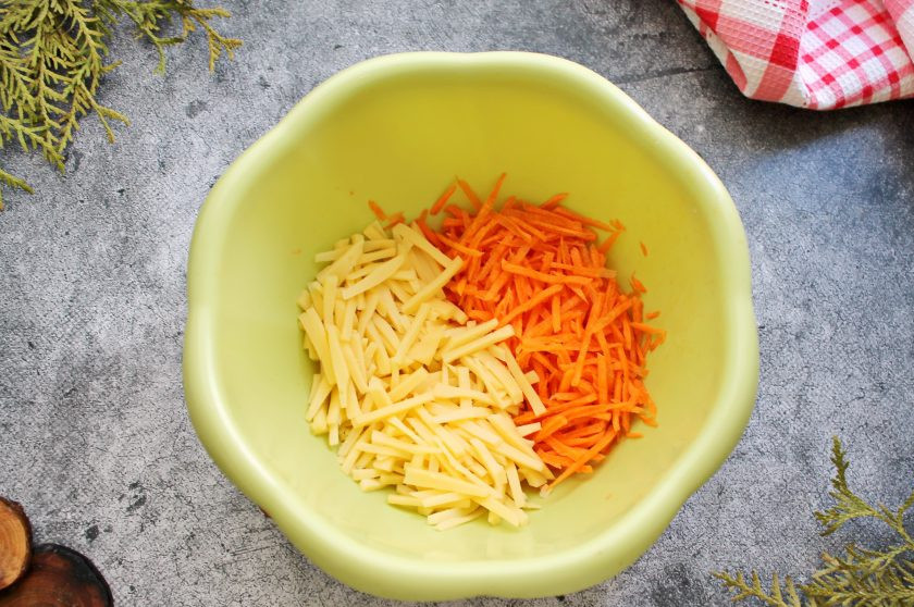 1. Этап. Салат Гнездо глухаря с колбасой: Свежую морковь и твердый сыр порежьте тонкой соломкой и выложите в салатник.
