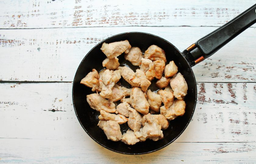 1. Этап. Мясо по-крестьянски: Свинину сполосните, обсушите и порежьте на кусочки. Выложите мясо в сковороду после обжаривания овощей и жарьте до румяной корочки, примерно 7-8 минут. Все посолите, поперчите и переложите мясо в форму для запекания.