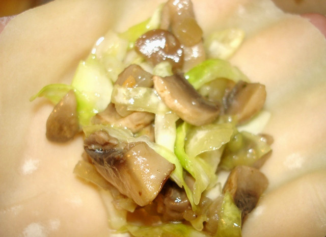 1. Этап. Вареники с капустой и грибами: На каждый кружочек теста кладем по столовой ложке приготовленной начинки, скрепляем края и формируем вареник.