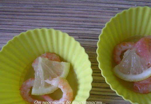 1. Этап. Креветки в шампанском: Семгу нарежьте ломтиками. Лимон кружочками, затем еще на 3-4 части. Уложите в формочки несколько креветок, ломтик семги и кусочки лимона.