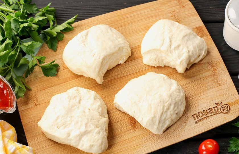 1. Этап. Пицца с сыром в мультиварке: Разделите тесто на 4 части.