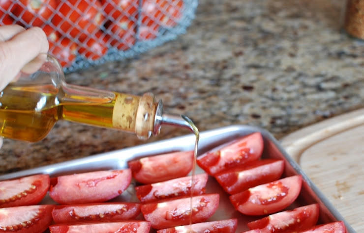 1. Этап. Помидоры, сушеные в духовке: Сверху щедро сбрызгиваем помидоры оливковым маслом.